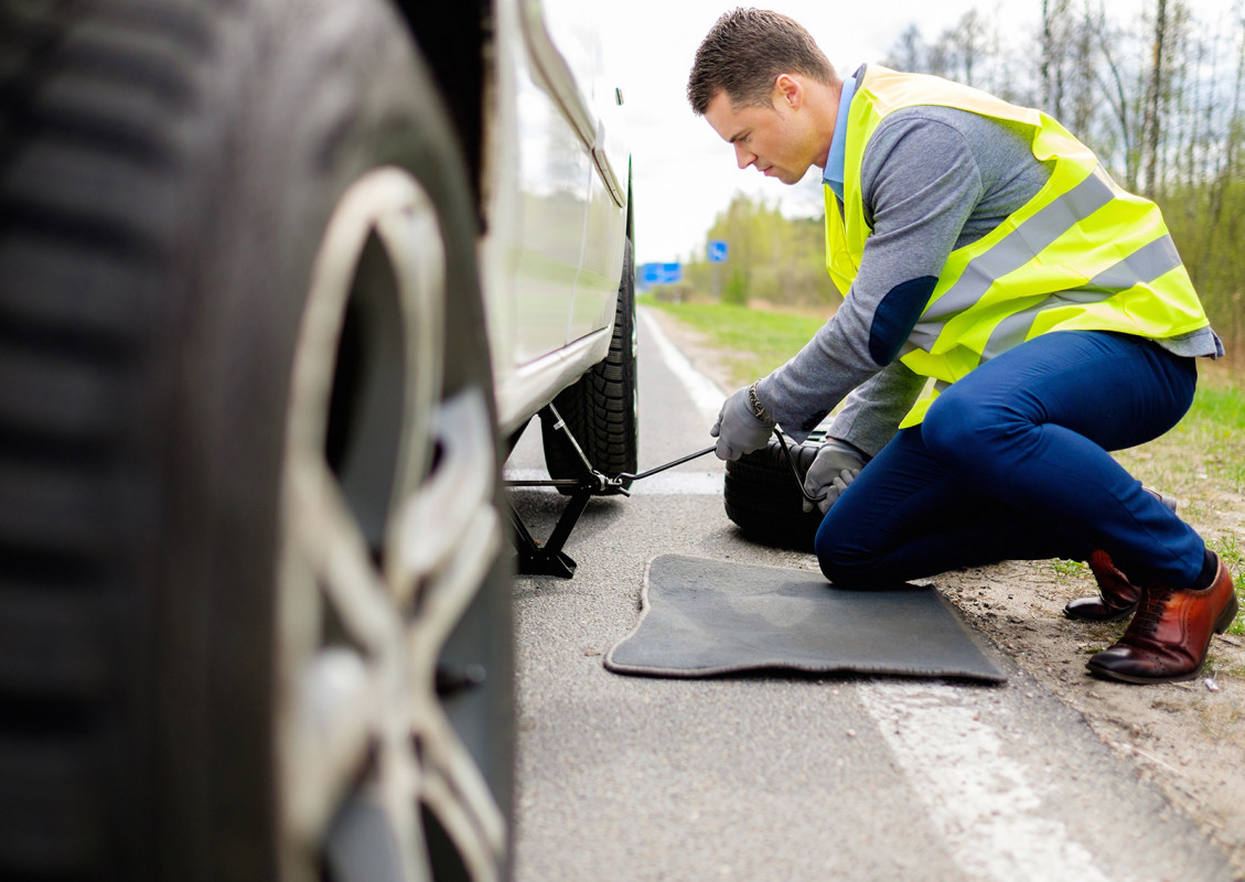 Man changing wheel on a roadside