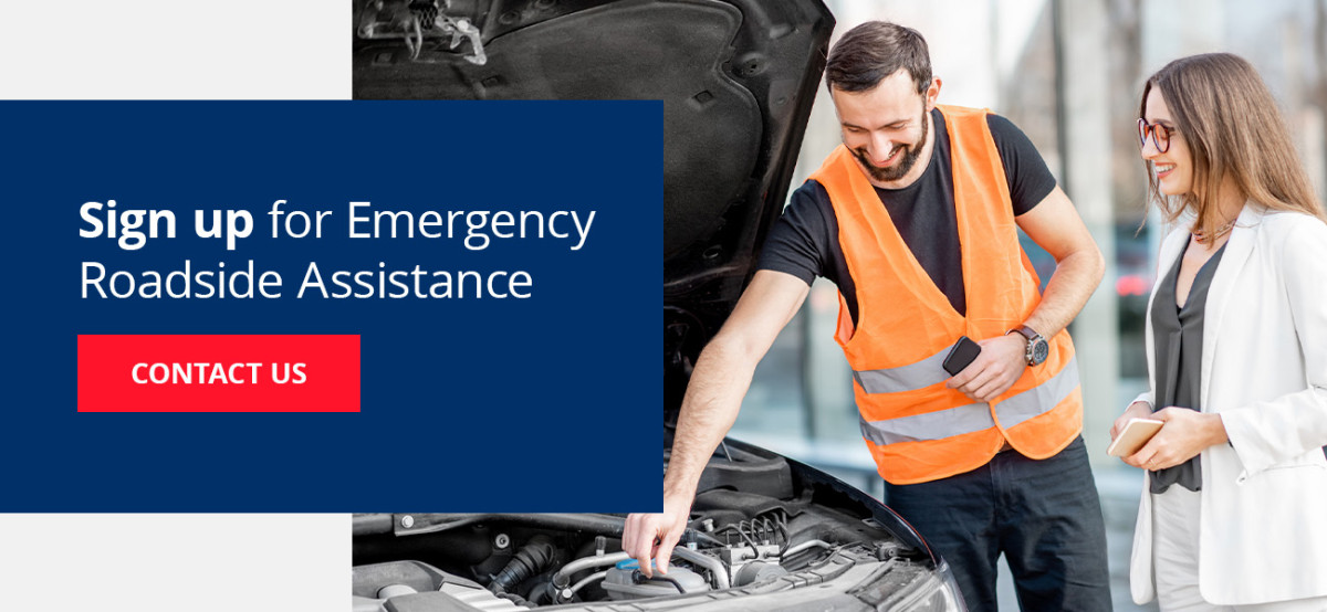 Mechanic showing woman something under her car's hood