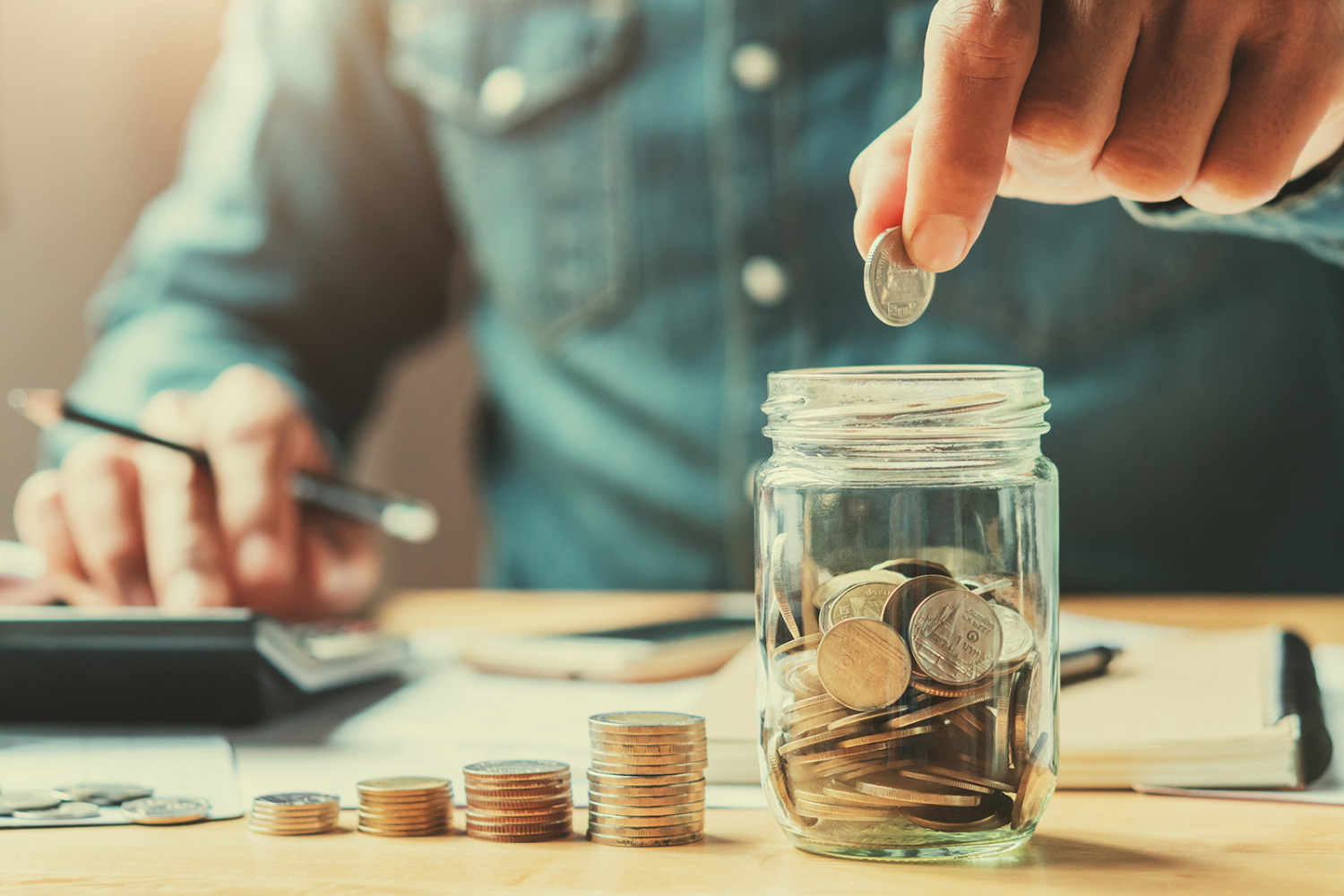 Person adding money in a jar