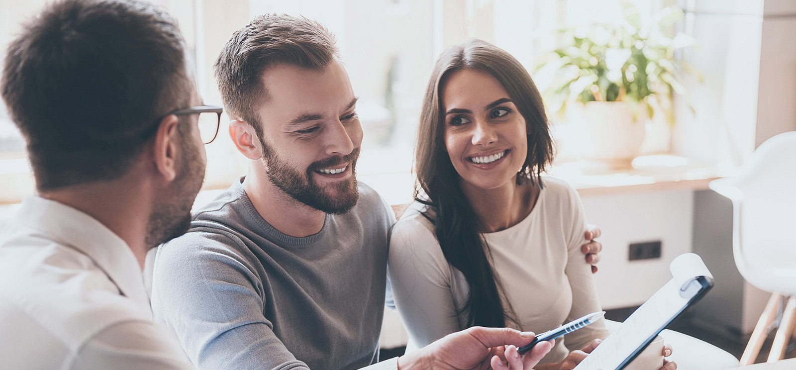 Couple talking with business adviser with contract