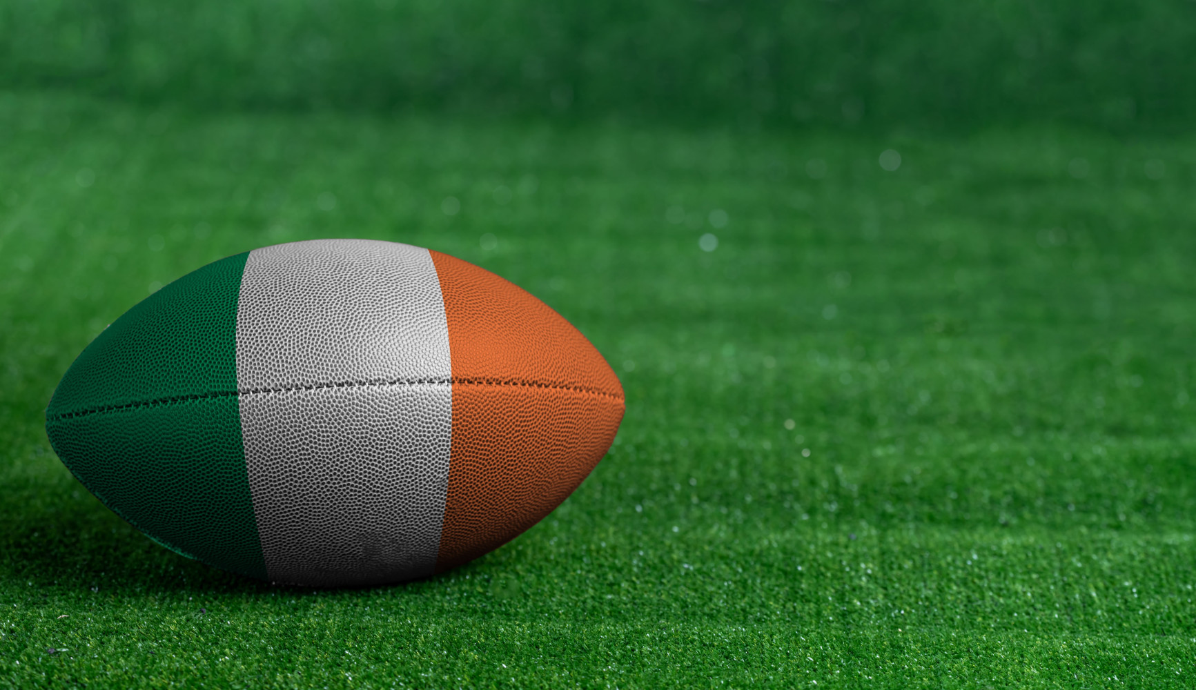 Football on a grassy field in the Irish flag colors