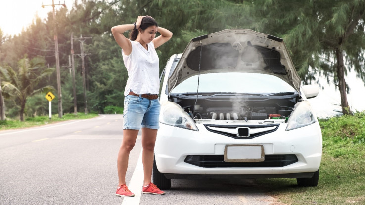 girl standing next to broken down car