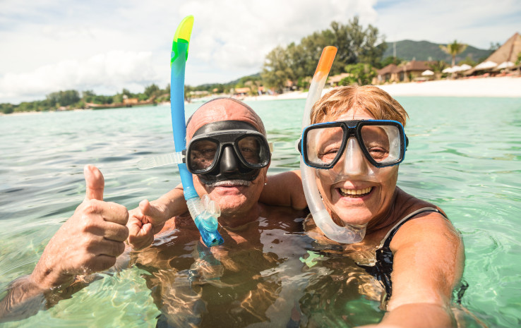 Seniors swimming with snorkels and facemasks on