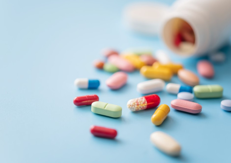 Medication on blue table from open bottle