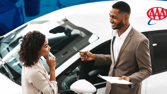 Woman discussing purchase with car salesman