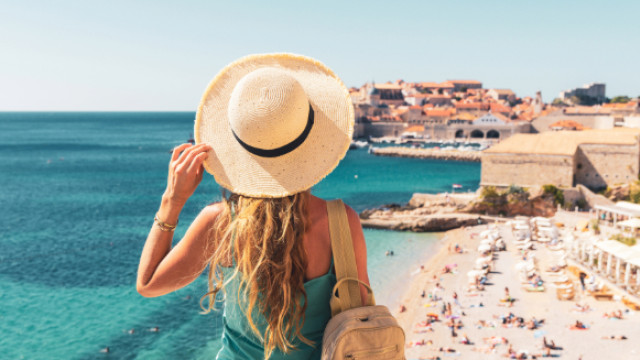 girl with hat looking at coast