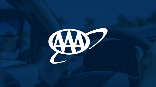 Hands on the steering wheel with the AAA logo
