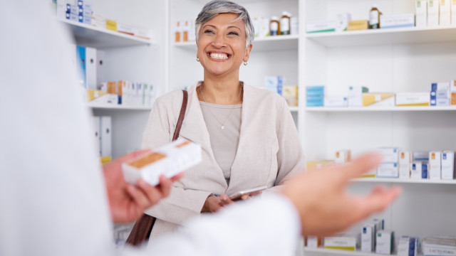 Woman in Pharmacy chatting with person in white coat 