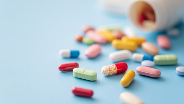Medication on blue table from open bottle