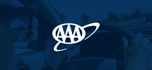 Hands on the steering wheel with the AAA logo