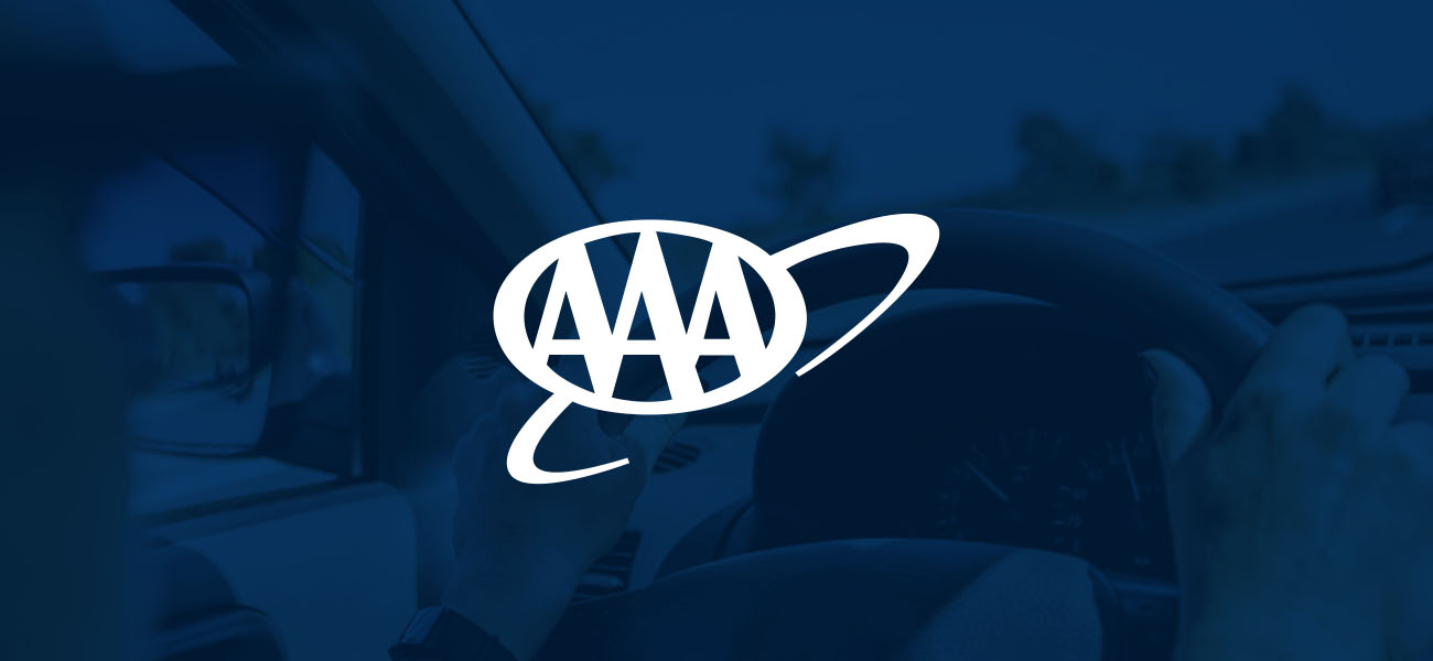 Hands on the steering wheel with the AAA logo
