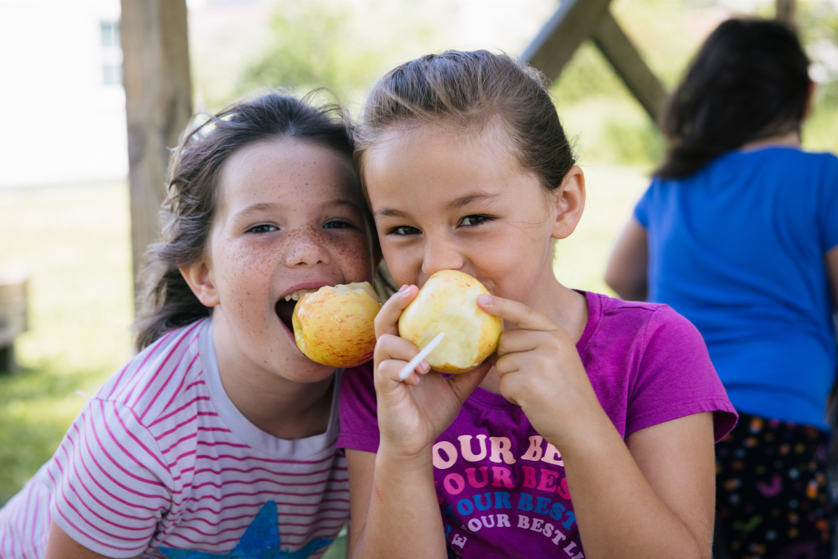2 girls eating an apple