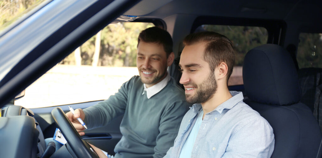 two people in a car, taking a drivers test