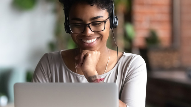 person with headset on laptop